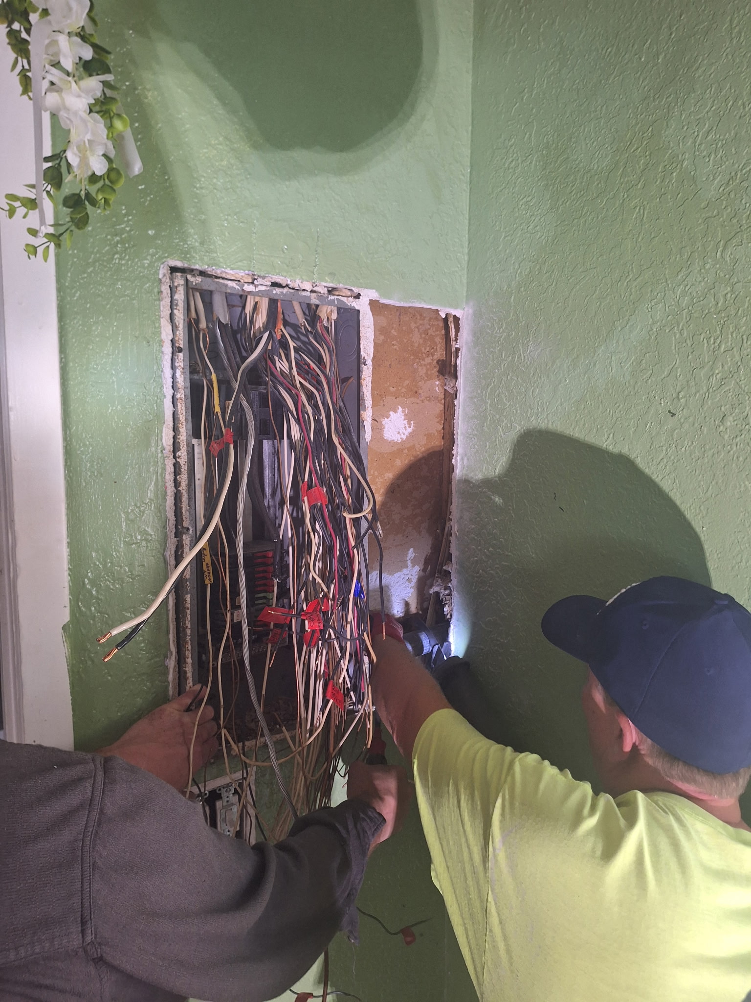 Two electricians troubleshooting panel